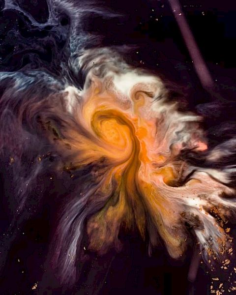 The image shows a swirl of vibrant colors, primarily oranges, and yellows, resembling a cosmic nebula against a dark background.