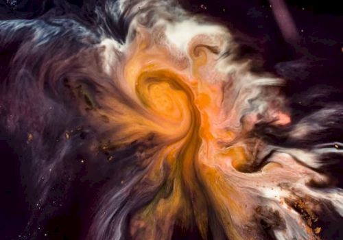 The image shows a swirl of vibrant colors, primarily oranges, and yellows, resembling a cosmic nebula against a dark background.